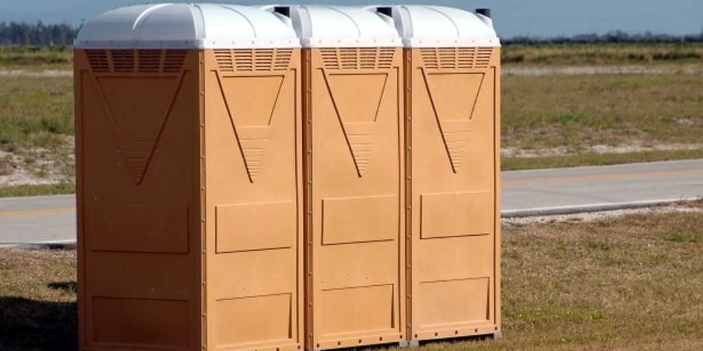 porta potty in a camping setting surrounded by nature