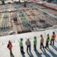 seven construction workers standing on white field